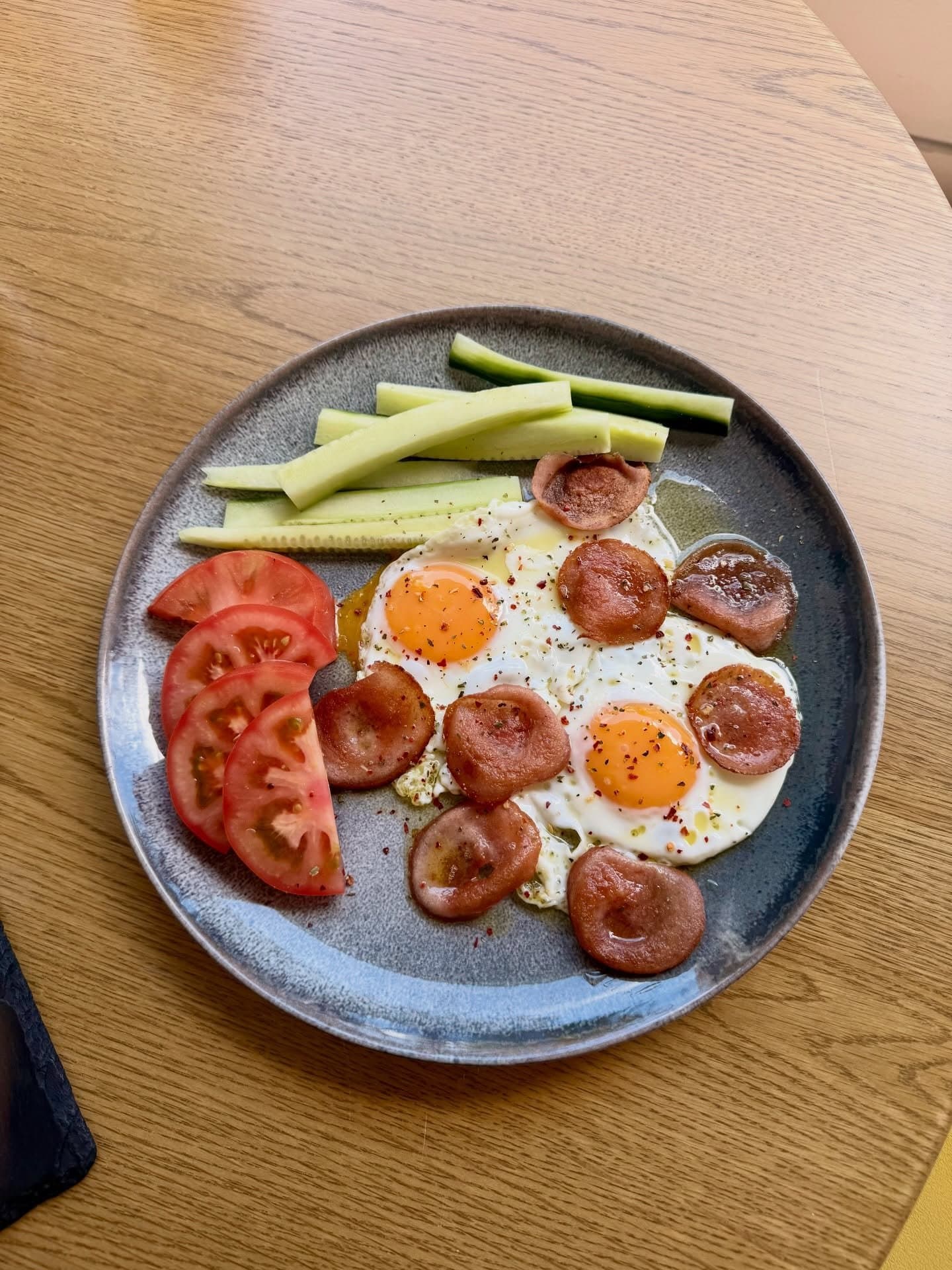 Desayuno de huevos, chorizo, tomate y pepino
